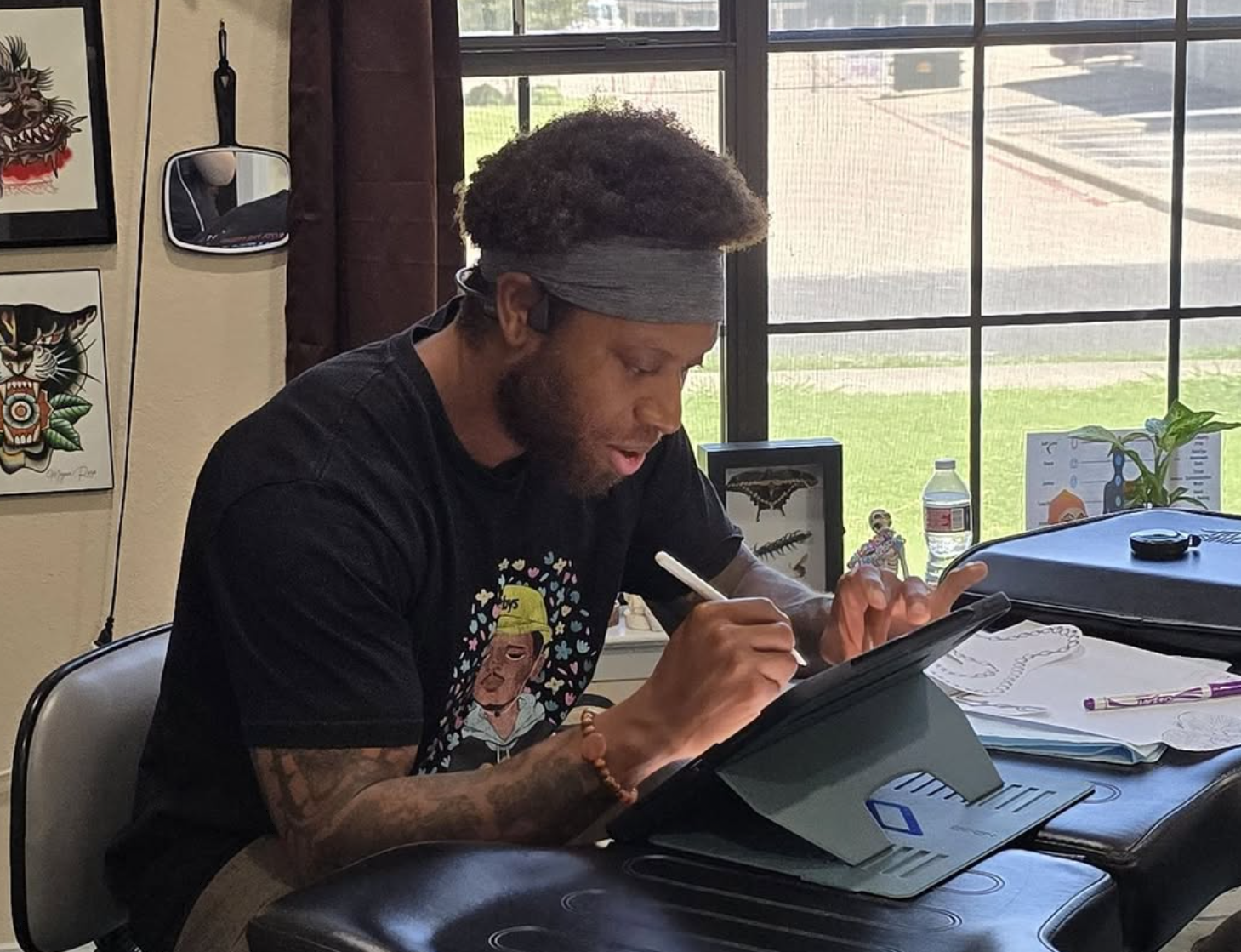 Qwami Tucker tattoo artist drawing designs at Bangarang Tattooing Company